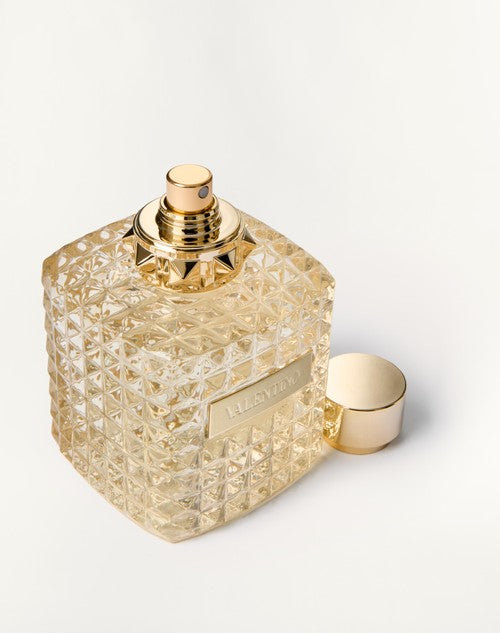 Decorative perfume bottle with gold cap on a light background