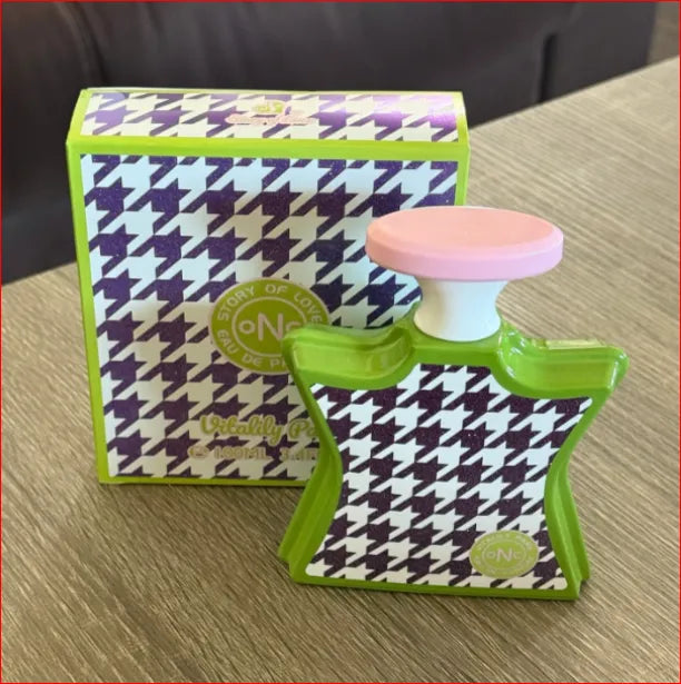 Perfume bottle with houndstooth pattern and matching box on a wooden surface