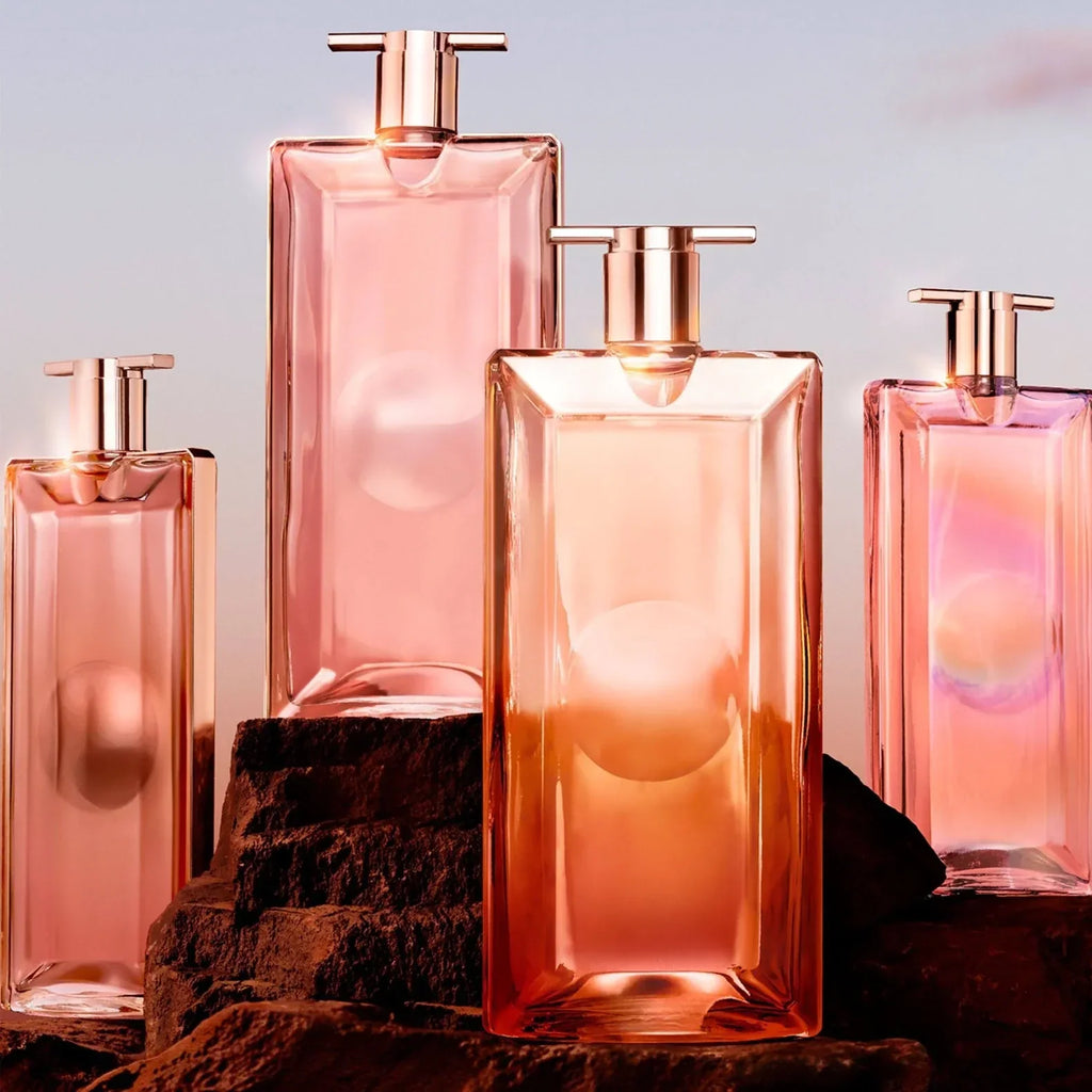 Set of pink perfume bottles with gold caps on a wooden surface