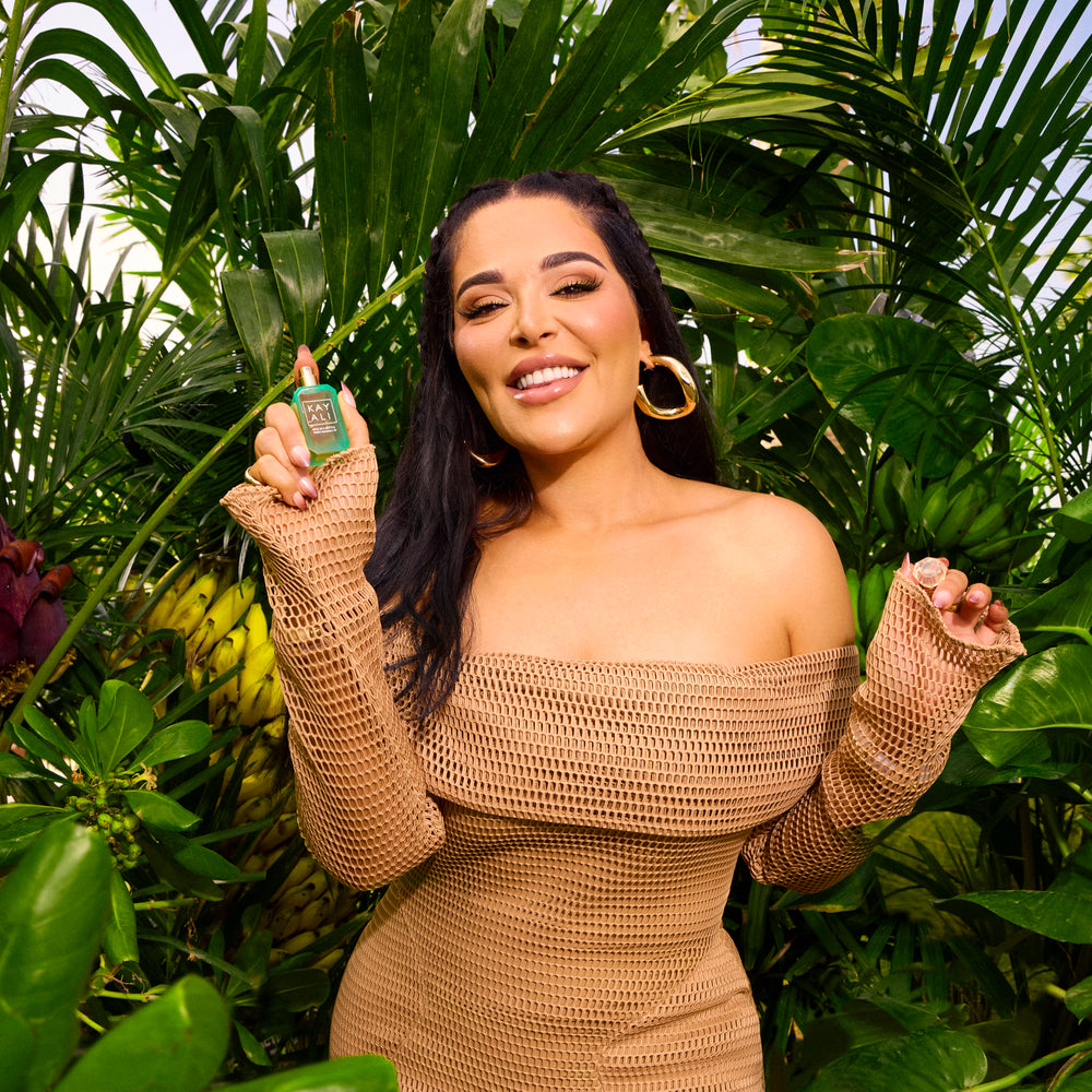 Woman holding a product in front of green foliage